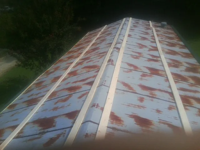 Rusted metal roof panels with new wood purlins before replacement — Storm Damage Roof Repair in Swan by Roofing Brothers